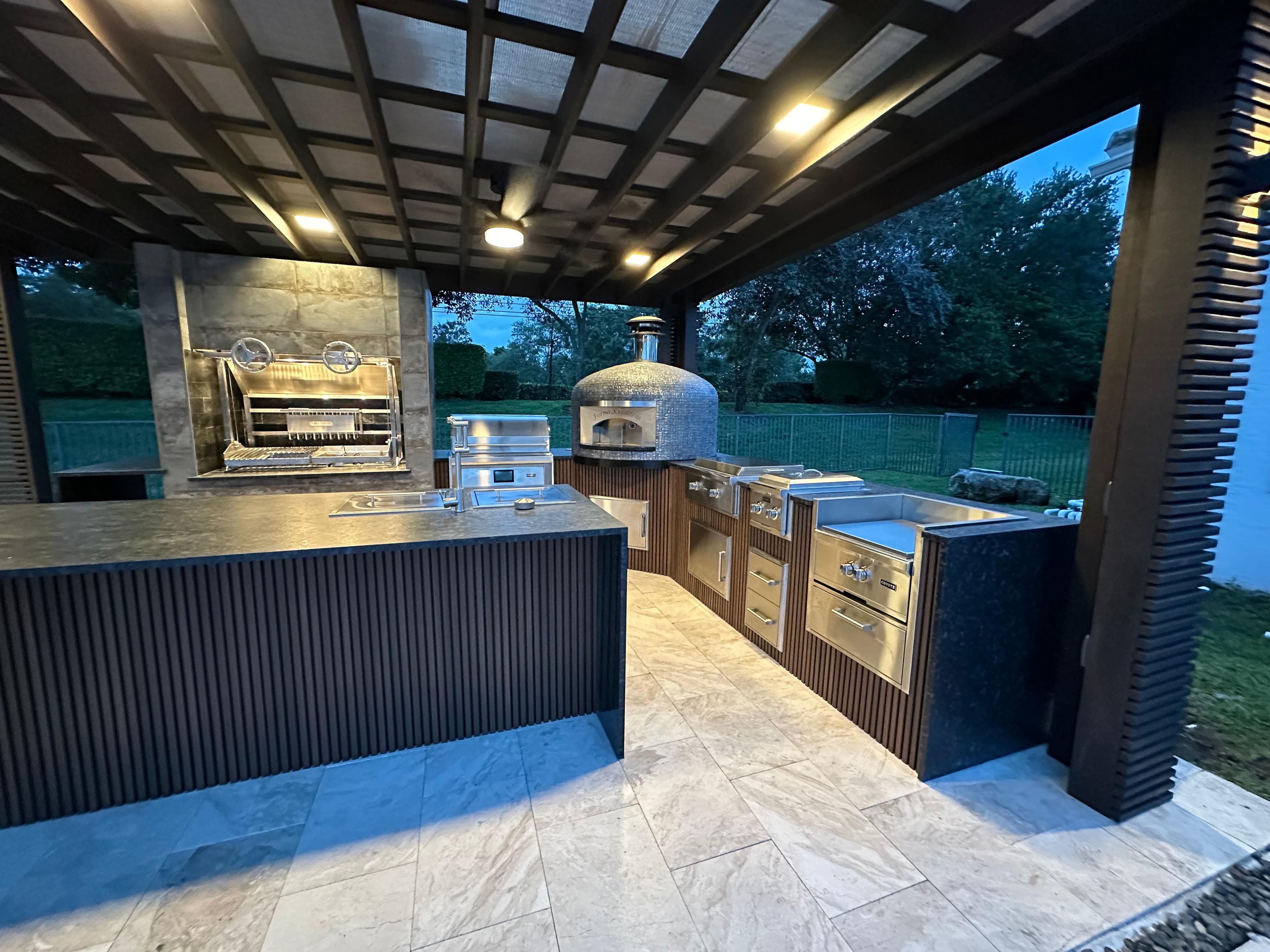 Outdoor kitchen with fire feature and evening ambiance